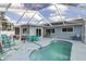 Screened-in pool area featuring a sparkling pool, patio furniture and sunny skies at 11731 Linden Dr, Spring Hill, FL 34608
