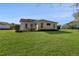 Rear view of a house with a patio and large lawn at 11830 Wax Myrtle Ct, New Port Richey, FL 34654