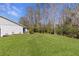 Side yard of house with green lawn and trees at 11830 Wax Myrtle Ct, New Port Richey, FL 34654
