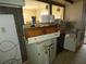 A cluttered kitchen with exposed countertops and cabinets needing renovation at 13737 Michelle Ave, Hudson, FL 34667