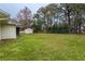 Large backyard with grassy lawn, storage shed, and chain link fence at 1378 Haulover Ave, Spring Hill, FL 34608