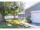 Home with gray siding, stone accents, and a walkway leading to the garage at 14004 Cascade Ln, Tampa, FL 33618