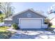 Gray house with white garage door, stone accents, and a basketball hoop in the yard at 14004 Cascade Ln, Tampa, FL 33618