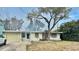 Ranch-style home with attached garage and mature trees at 1624 Sea Breeze Dr, Tarpon Springs, FL 34689