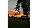Vibrant sunset over a waterfront property with palm trees and a gazebo at 1624 Sea Breeze Dr, Tarpon Springs, FL 34689