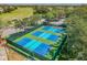 Aerial view of four well-maintained pickleball courts with surrounding fencing at 18325 Daventry Ct, Hudson, FL 34667