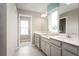 Elegant bathroom with double vanity, large mirror, and a view into another room at 2473 White Ladyfish Rd, Wimauma, FL 33598