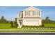 Two-story house with light beige exterior, landscaping, and a two-car garage at 2473 White Ladyfish Rd, Wimauma, FL 33598