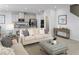 Living room with beige couch, ottoman, kitchen in background at 2473 White Ladyfish Rd, Wimauma, FL 33598