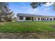 View of the home's backyard, showcasing a large grassy area and patio at 410 Candlestone Ct, Spring Hill, FL 34609