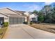 Single-story home exterior with a two-car garage and landscaped yard at 410 Candlestone Ct, Spring Hill, FL 34609