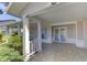 Side view of covered porch with tiled flooring and white columns at 4710 Parkdale Ln, New Port Richey, FL 34655
