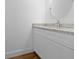 Bathroom vanity features white cabinets, granite countertop, modern faucet, and round mirror at 5173 Pacific Ave, Spring Hill, FL 34607