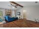 Living area with hardwood floors, stone fireplace, and ceiling fan at 5371 Joyner Ave, Spring Hill, FL 34608