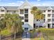 Heather Cove II building exterior, featuring a gated entrance and palm trees at 5557 Sea Forest Dr # 117, New Port Richey, FL 34652