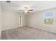 Spacious bedroom with ceiling fan, window, and access to bathroom at 578 Argyll Dr, Spring Hill, FL 34609