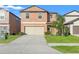 Two-story house with beige exterior, two-car garage, and manicured lawn at 578 Argyll Dr, Spring Hill, FL 34609