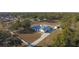 Aerial view of a white house with gray roof and detached barn on a large lot at 9331 Elida Rd, Spring Hill, FL 34608