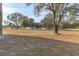 Large backyard with mature trees and a white fence at 9331 Elida Rd, Spring Hill, FL 34608