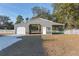 Gray metal barn with white garage door and horse stalls at 9331 Elida Rd, Spring Hill, FL 34608
