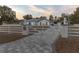 Custom entrance gate with lion statues and paver driveway at 9331 Elida Rd, Spring Hill, FL 34608