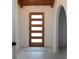 Modern entryway with a stylish wood door and geometric rug at 9331 Elida Rd, Spring Hill, FL 34608