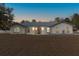 White single-story home with gray tile roof at dusk; landscaped yard at 9331 Elida Rd, Spring Hill, FL 34608