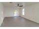 Simple living room with grey tile floors and ceiling fan at 9331 Elida Rd, Spring Hill, FL 34608