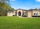 Single-story home with arched entryway and lush landscaping at 10331 Fox Sparrow Ave, Weeki Wachee, FL 34613