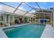 A beautiful screened-in backyard pool with adjacent covered patio seating and dining area at 10473 Claymore St, Spring Hill, FL 34608