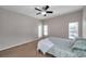 Well-lit bedroom with neutral walls, plush carpet, a ceiling fan, and natural light from large windows overlooking the backyard at 11602 Bathgate Ct, New Port Richey, FL 34654