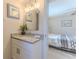 Bathroom vanity area with granite counters, white cabinets, and doorway to the main bedroom at 13531 Allyn Dr, Hudson, FL 34667