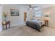 Bright bedroom with wood-look flooring, ceiling fan and a glimpse into the ensuite bathroom at 13531 Allyn Dr, Hudson, FL 34667