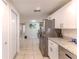 Modern kitchen with stainless steel appliances, white cabinets, and a view into the living area at 13531 Allyn Dr, Hudson, FL 34667