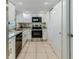 Bright kitchen featuring white cabinetry, stainless steel appliances, and tile flooring at 13531 Allyn Dr, Hudson, FL 34667
