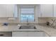 Close-up of kitchen sink with granite countertops and a window view of the canal at 13531 Allyn Dr, Hudson, FL 34667