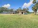 Spacious backyard with lush lawn, mature trees, shed and neighboring house at 14034 Water Tower Dr, Hudson, FL 34667