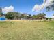 Expansive backyard with lush green grass and a view of the home, shed, and blue storage container at 14034 Water Tower Dr, Hudson, FL 34667