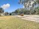 A spacious backyard with concrete slab, mature trees, and ample room for activities at 14034 Water Tower Dr, Hudson, FL 34667