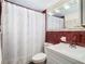 Bathroom featuring a white vanity and toilet, paired with decorative, red tile walls at 14034 Water Tower Dr, Hudson, FL 34667