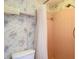 Full bathroom showcasing retro pink tile in the shower and vintage wallpaper at 14034 Water Tower Dr, Hudson, FL 34667