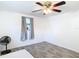 A bright bedroom with grey curtains and a fan next to the window and modern wood-look floors at 14034 Water Tower Dr, Hudson, FL 34667