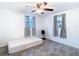 A bright, minimalist bedroom featuring neutral walls, modern wood-look floors, and natural light from two windows at 14034 Water Tower Dr, Hudson, FL 34667