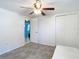 A clean, open bedroom featuring white walls, a ceiling fan, closet, and stylish wood-look flooring at 14034 Water Tower Dr, Hudson, FL 34667