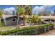 Charming single-story home with beautiful landscaping, complemented by mature palm trees and a convenient carport at 14034 Water Tower Dr, Hudson, FL 34667
