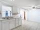 Updated kitchen with modern white cabinets, stainless steel sink and view to adjoining room at 14034 Water Tower Dr, Hudson, FL 34667