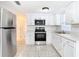 Bright kitchen with stainless steel appliances, white cabinets, and tile flooring at 14034 Water Tower Dr, Hudson, FL 34667