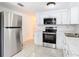 Modern kitchen featuring stainless steel appliances, white cabinetry, and granite countertops at 14034 Water Tower Dr, Hudson, FL 34667