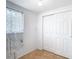 Bright laundry room featuring tile flooring, a window, and a closet with bifold doors at 14034 Water Tower Dr, Hudson, FL 34667