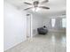 View of the spacious living room featuring a ceiling fan, neutral walls, and tile flooring throughout at 14034 Water Tower Dr, Hudson, FL 34667